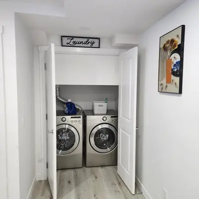 a laundry room with two washing machines in it at 2 bedrooms luxury basement suite close to Calgary airport in Calgary