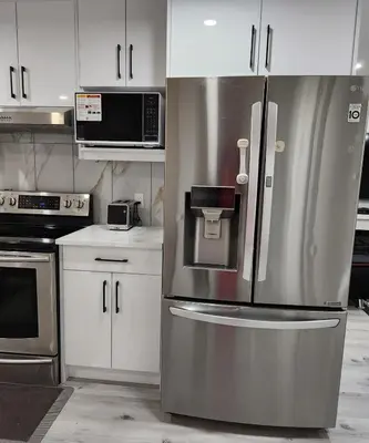 a stainless steel refrigerator in a kitchen with white cabinets at 2 bedrooms luxury basement suite close to Calgary airport in Calgary