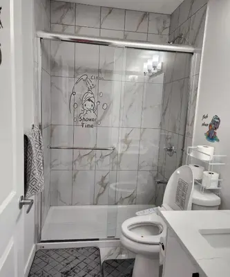 a bathroom with a shower and a toilet at 2 bedrooms luxury basement suite close to Calgary airport in Calgary