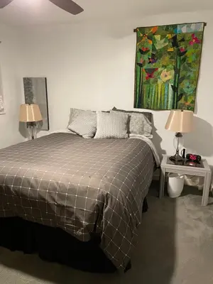 a bedroom with a bed and a painting on the wall at Oyster River Guest Room in Campbell River