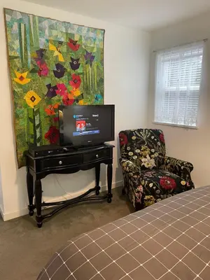 a bedroom with a tv on a table and a chair at Oyster River Guest Room in Campbell River