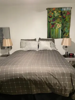 a bedroom with a bed with two lamps and a painting at Oyster River Guest Room in Campbell River