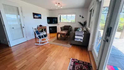 a living room with a couch and a fireplace at Oceanfront Garden Suite - Stunning Views & Wildlife in Halfmoon Bay