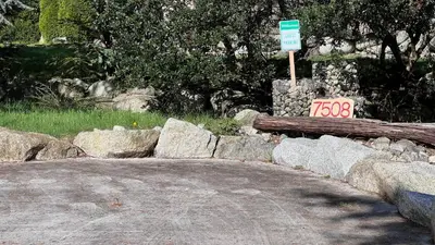 a sign sitting on top of a pile of rocks at Oceanfront Garden Suite - Stunning Views & Wildlife in Halfmoon Bay