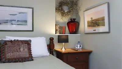 a bedroom with a bed and a table with a lamp at Cole's Bay Vacation Retreat Cole's Bay Suite in YYJ