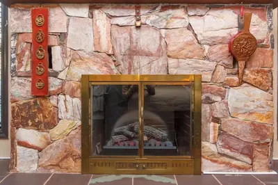a stone wall with a fireplace in front of it at Cole's Bay Vacation Retreat Library Room in YYJ
