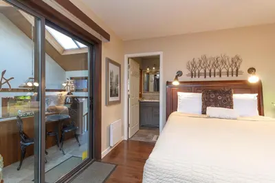 a bedroom with a large bed and a desk at Cole's Bay Vacation Retreat Library Room in YYJ