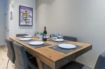 a dining room table with glasses and a bottle of wine at Whistler Village North Retreat - Private Hot tub in Whistler