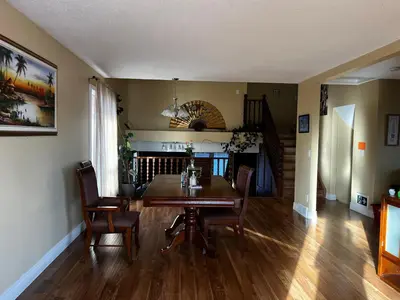 a dining room with a wooden table and chairs at Biddington private room close airport! in Calgary