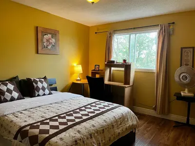 a bedroom with a bed and a window at Biddington private room close airport! in Calgary