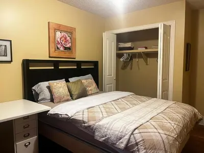 a bedroom with a bed with a desk and a window at Biddington private room close airport! in Calgary