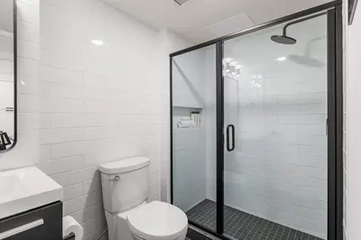 a bathroom with a toilet and a glass shower at Newly Built 2BR Mountain Escape in DT Canmore! in Canmore