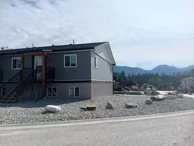 a house with rocks on the side of the road at 3 Bed Townhouse, Mountain Views, Large Deck, Air Con, Garage in Invermere