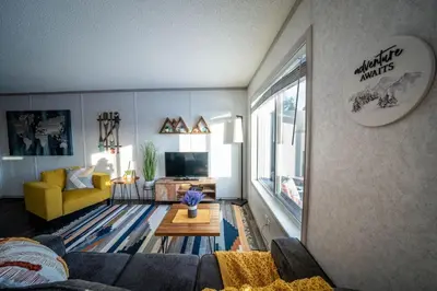 a living room with a couch and a table at 3 Bed Townhouse, Mountain Views, Large Deck, Air Con, Garage in Invermere