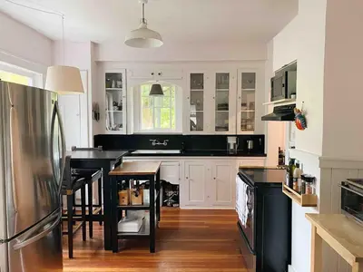 a kitchen with white cabinets and black counter tops at Craftsman Home in popular East Village in Vancouver