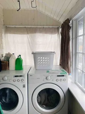 a laundry room with two washing machines and a window at Craftsman Home in popular East Village in Vancouver
