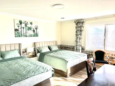 a bedroom with two beds and a table at Spacious Bedroom with Two Queen Sized Bed in Richmond