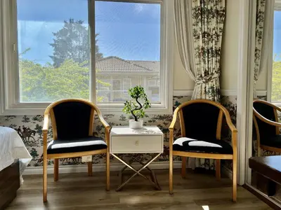 two chairs and a table in a room with a window at Spacious Bedroom with Two Queen Sized Bed in Richmond