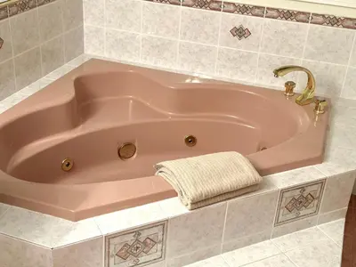 a pink bath tub with a towel in a bathroom at Spacious Bedroom with Two Queen Sized Bed in Richmond