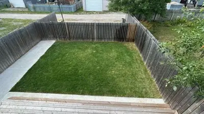 a garden with a wooden fence and green grass at 2 BDRM Homes on 2nd Avenue in Fernie