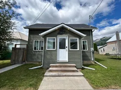 a small house with a white door in a yard at 2 BDRM Homes on 2nd Avenue in Fernie