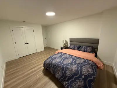 a bedroom with a king sized bed with an orange blanket at Calm & Cozy Private Suite in Surrey