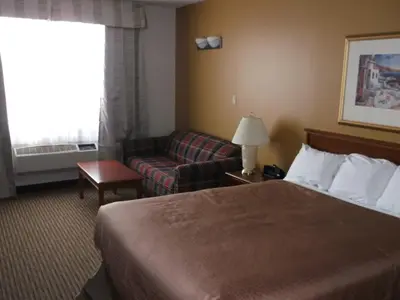 a hotel room with a bed and a couch at Foxwood Inn and Suites in Fox Creek