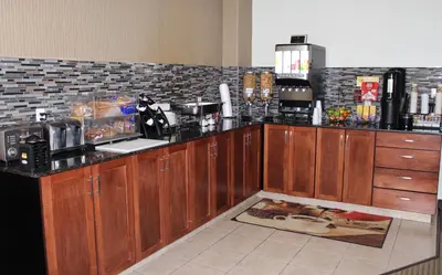 a kitchen with wooden cabinets and a counter top at Foxwood Inn and Suites in Fox Creek