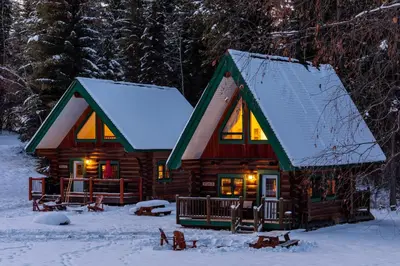 a log cabin in the snow with lights on at Moberly Lodge in Golden