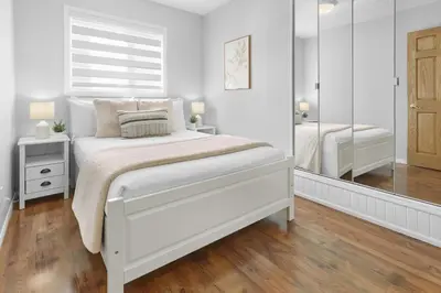 a white bedroom with a bed and a mirror at Fabulous Home-King bed-Easy Access to EVERyTHING! in Edmonton