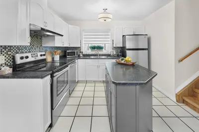 a kitchen with white cabinets and black counter tops at Fabulous Home-King bed-Easy Access to EVERyTHING! in Edmonton