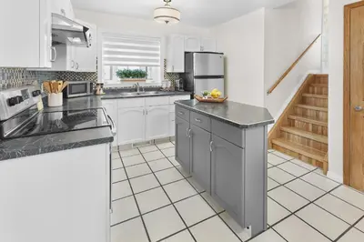a kitchen with white cabinets and black counter tops at Fabulous Home-King bed-Easy Access to EVERyTHING! in Edmonton