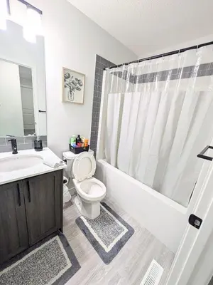 a bathroom with a toilet and a tub and a sink at Edith Gate Luxe Bedroom 2 Homestay in Calgary