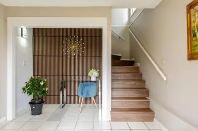 a staircase in a house with a blue chair at Oak Park House in Vancouver in Vancouver