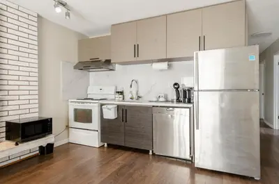 a kitchen with a stainless steel refrigerator and cabinets at Oak Park House in Vancouver in Vancouver
