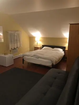 a bedroom with a large white bed and a window at Crowsnest Vineyards Guesthouse in Keremeos