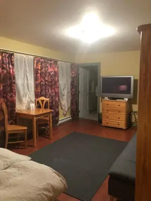a room with a bed and a tv and a table at Crowsnest Vineyards Guesthouse in Keremeos