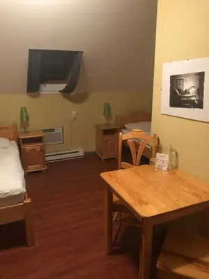 a room with a table and a bed and a tv at Crowsnest Vineyards Guesthouse in Keremeos