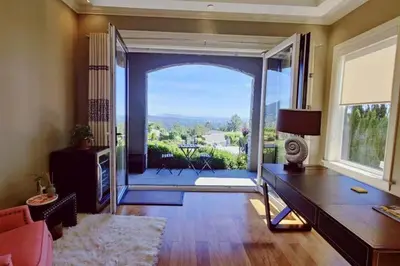 a living room with a large sliding glass door at Stunning view in elegant 1 bedroom suite in West Vancouver