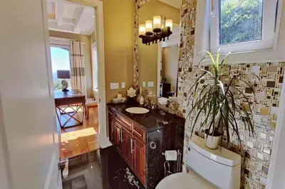 a bathroom with a sink and a toilet and a mirror at Stunning view in elegant 1 bedroom suite in West Vancouver
