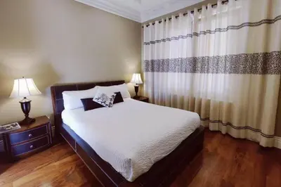 a bedroom with a bed and two lamps and a curtain at Stunning view in elegant 1 bedroom suite in West Vancouver