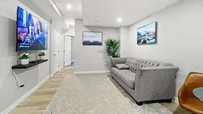 a living room with a couch and a tv at Serene Stays in Calgary