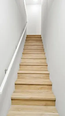 a staircase with wooden floor and white walls at Serene Stays in Calgary