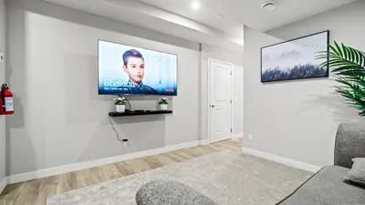 a living room with a flat screen tv on a wall at Serene Stays in Calgary