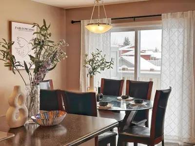a dining room with a table and chairs and a window at Entire Beautiful and Cozy Home in Edmonton