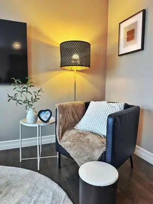 a living room with a chair and a lamp at Entire Beautiful and Cozy Home in Edmonton