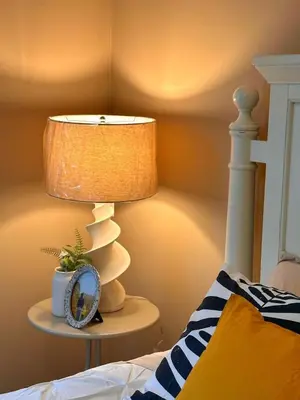 a lamp on a table next to a bed at Entire Beautiful and Cozy Home in Edmonton
