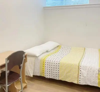a bed in a room with a desk and a chair at Beautiful place with Kitchen, Washing Machine, Internet near UBC, beach and DT in Vancouver