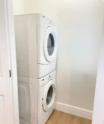 a washer and dryer in a white laundry room at Beautiful place with Kitchen, Washing Machine, Internet near UBC, beach and DT in Vancouver