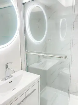 a bathroom with a shower and a sink and a mirror at Beautiful place with Kitchen, Washing Machine, Internet near UBC, beach and DT in Vancouver